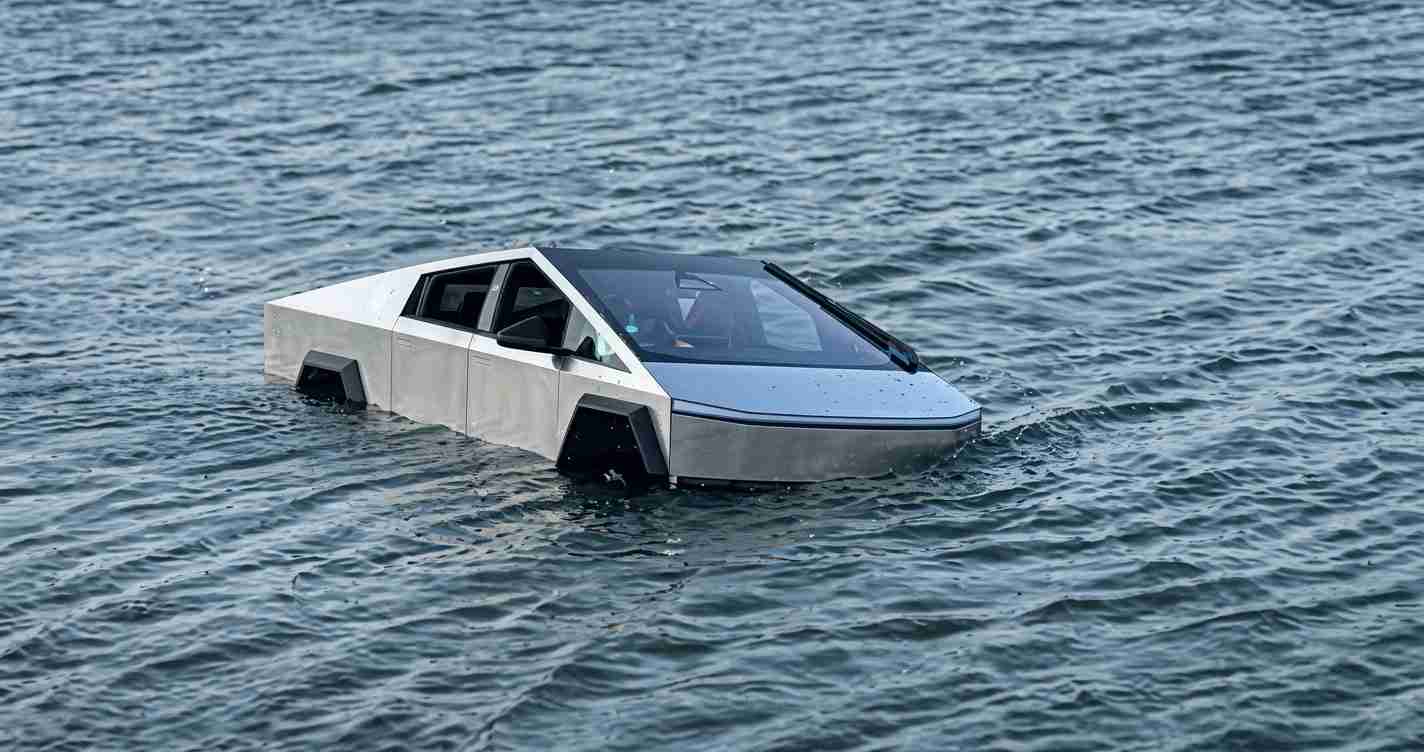 Futuristic silver car partly submerged in choppy sea, with the front end dipping into the water nearby ripples.