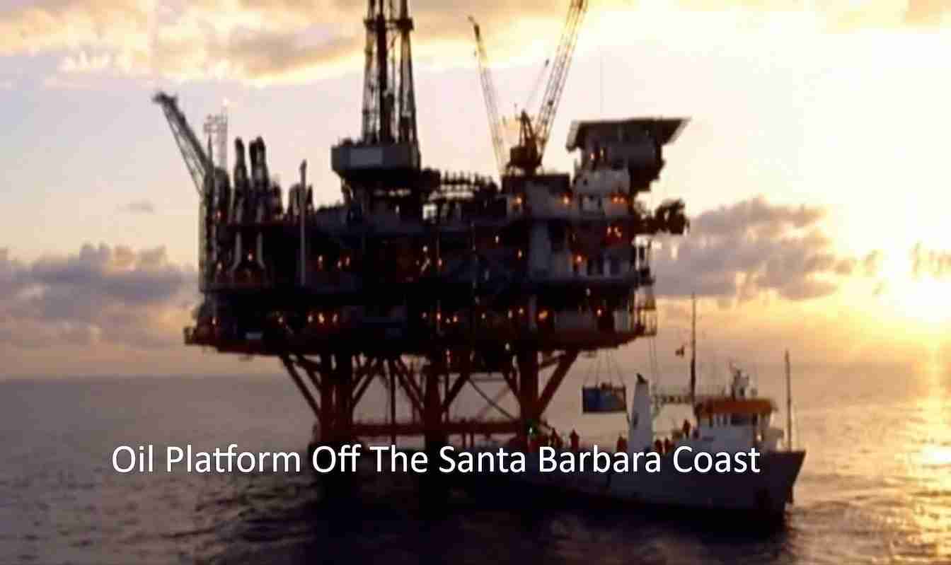 Offshore oil platform on stilts near the Santa Barbara coast at sunset, with a support boat nearby.