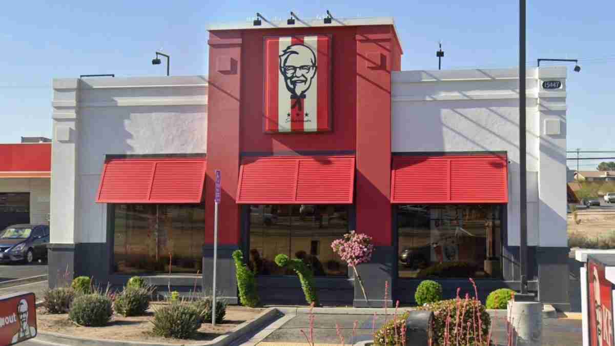 KFC restaurant exterior with a red facade, red awnings, and a Colonel Sanders sign above the entrance.
