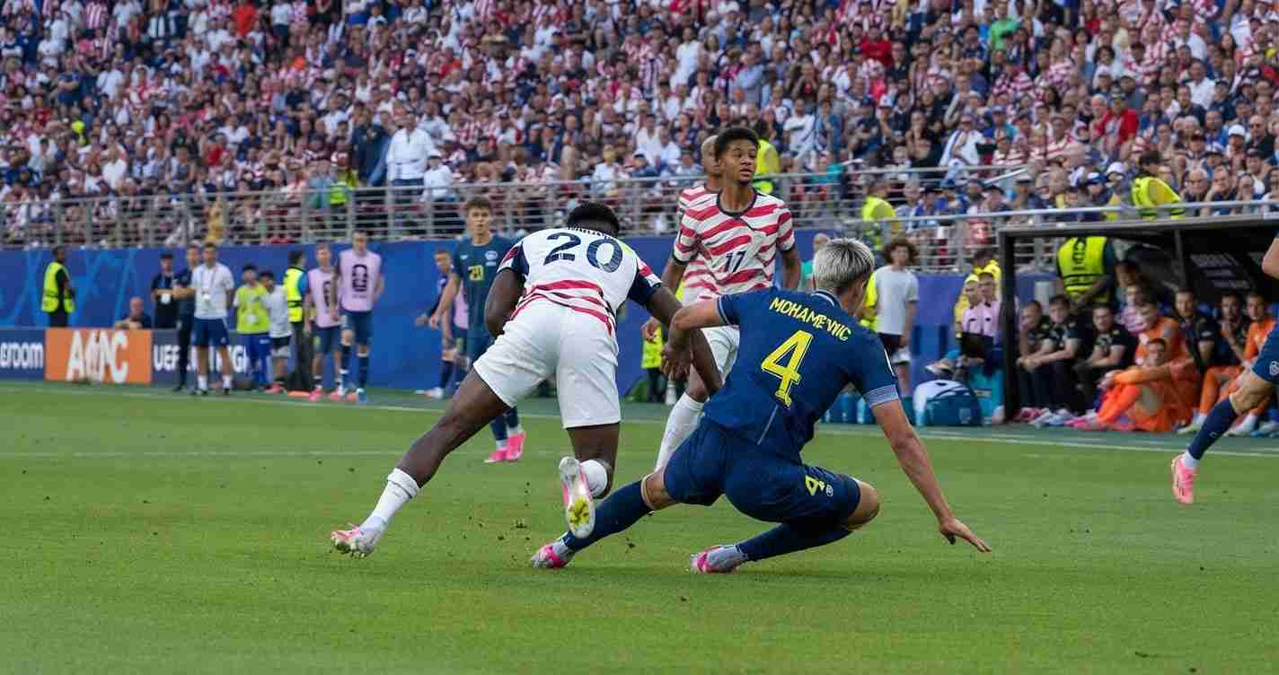 Soccer players contest the ball during a match as a sliding tackle unfolds with a full crowd in the stands behind."","Player in white with number 20 challenges the ball while a blue-jersey defender (number 4) slides in."","Action shot of a sliding tackle on a green field with spectators watching from the stands."","Two teams compete for the ball near the sideline, one player in white stripes and the other in blue."","Dynamic on-field moment: defender slides to intercept the ball as attackers approach."